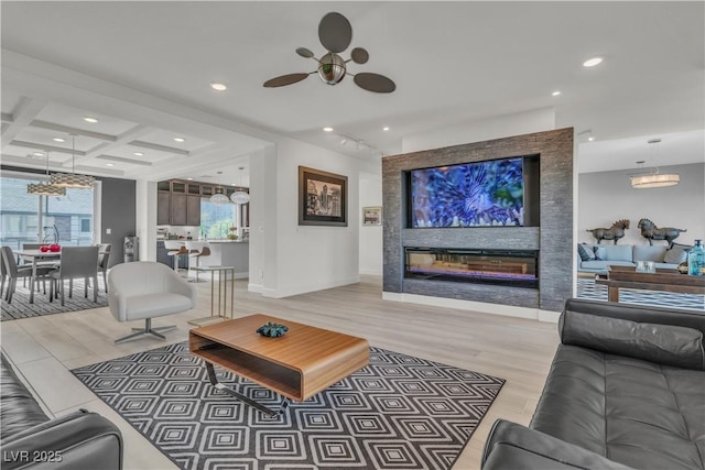 living area with a large fireplace, coffered ceiling, a wealth of natural light, and recessed lighting