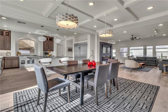 dining space with wood tiled floor, visible vents, coffered ceiling, and beam ceiling