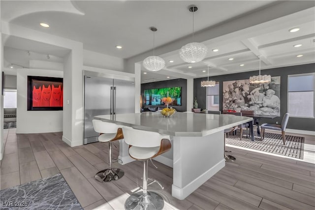 kitchen with recessed lighting, stainless steel built in fridge, wood tiled floor, and a center island