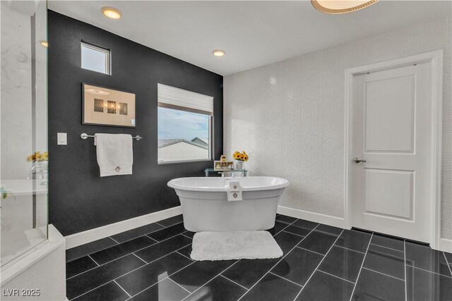 bathroom with tile patterned flooring, a wealth of natural light, and a tub