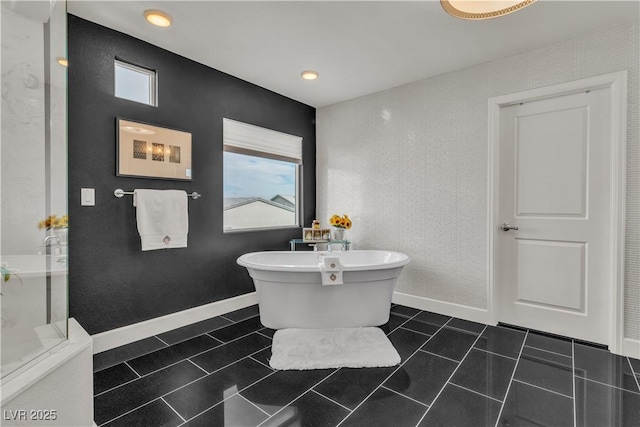 bathroom featuring plenty of natural light, tile patterned flooring, and a freestanding bath