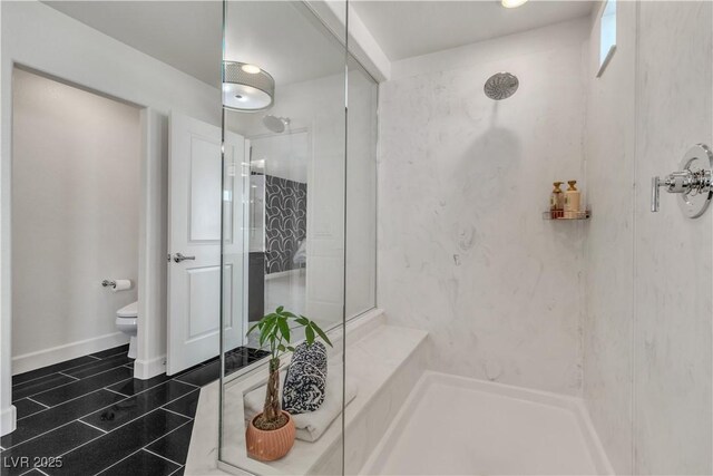 bathroom with toilet, a marble finish shower, and tile patterned floors