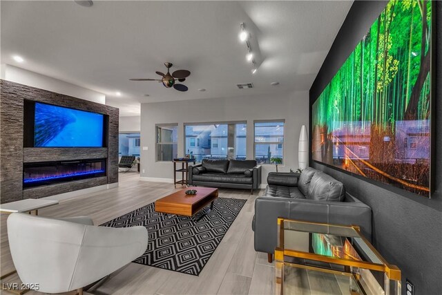 living room with ceiling fan, track lighting, and light wood-type flooring