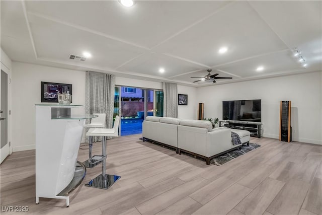 living room with baseboards, ceiling fan, visible vents, and light wood-style floors