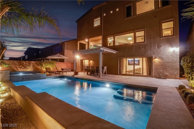 pool at twilight with a fenced in pool, a patio, fence, a pergola, and an in ground hot tub