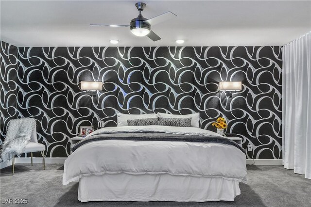 carpeted bedroom with wallpapered walls, ceiling fan, an accent wall, and baseboards