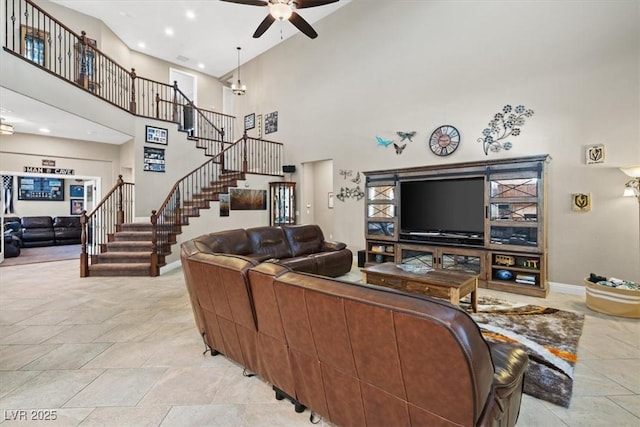 living room with ceiling fan and a high ceiling