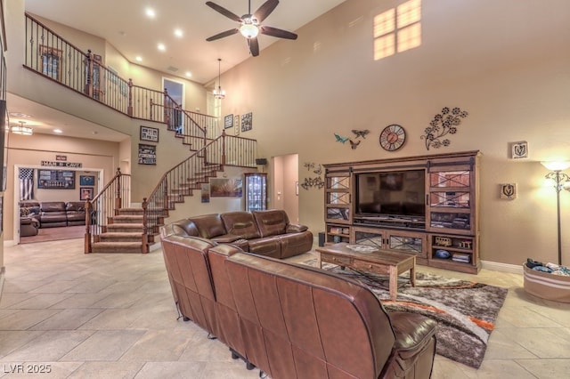 living room with ceiling fan and a towering ceiling