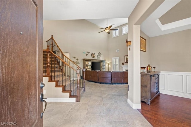 entrance foyer featuring a high ceiling, hardwood / wood-style floors, and ceiling fan