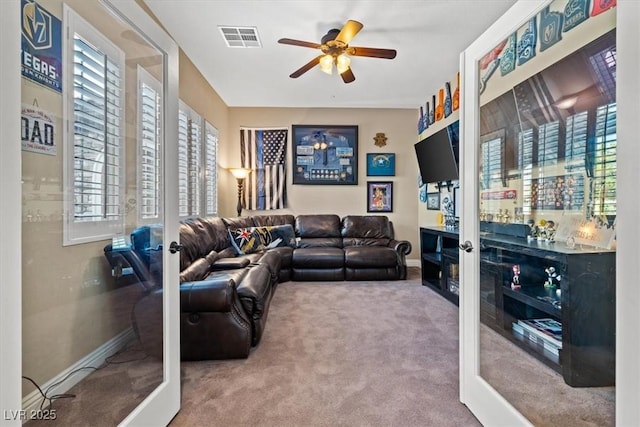 carpeted living room with french doors and ceiling fan