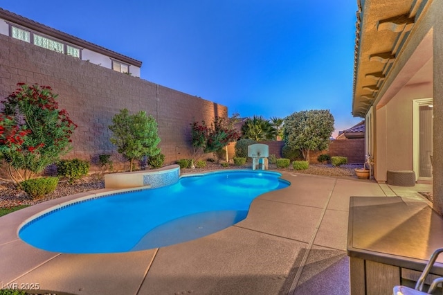 pool at dusk featuring a patio