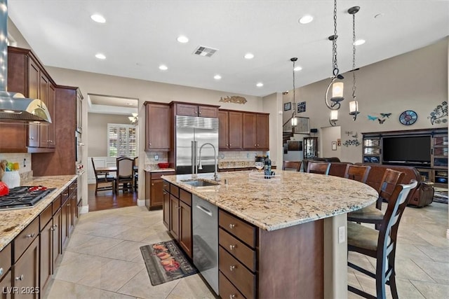 kitchen with sink, a breakfast bar, appliances with stainless steel finishes, a spacious island, and decorative backsplash