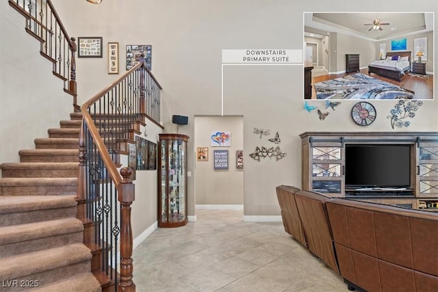 interior space featuring crown molding, a raised ceiling, ceiling fan, and a high ceiling