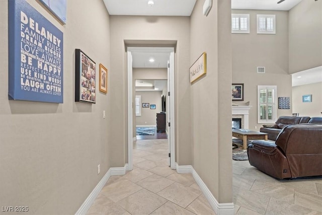 corridor featuring light tile patterned floors and a high ceiling