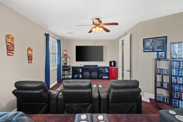 carpeted home theater with ceiling fan