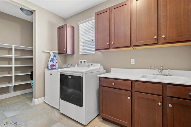 washroom featuring sink, washer and clothes dryer, and cabinets