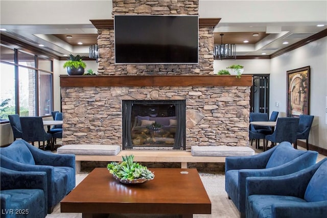 living room with crown molding, a tray ceiling, and a stone fireplace