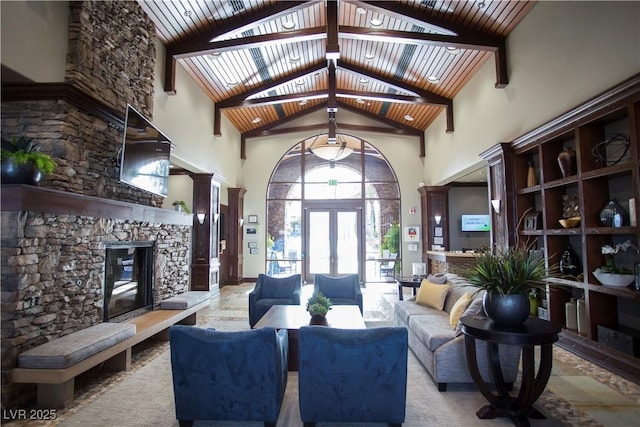 living room featuring french doors, a stone fireplace, high vaulted ceiling, and wooden ceiling