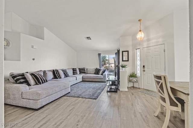 living room featuring high vaulted ceiling and light hardwood / wood-style flooring