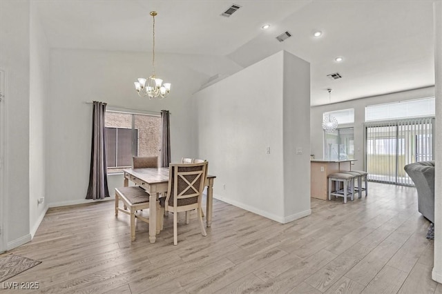 dining space with an inviting chandelier, vaulted ceiling, and light wood-type flooring