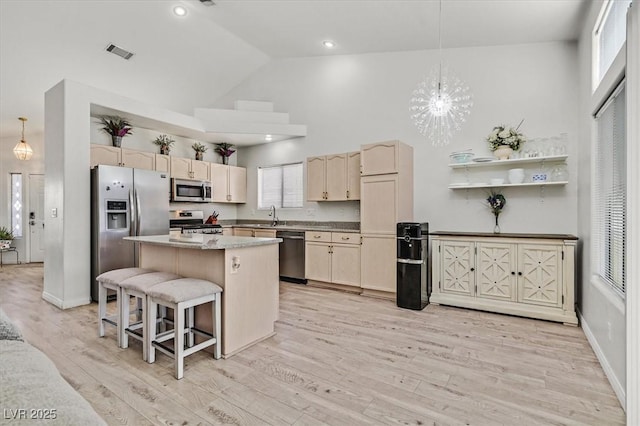 kitchen featuring an inviting chandelier, stainless steel appliances, a center island, and hanging light fixtures