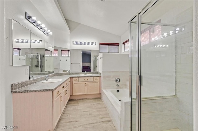 bathroom featuring vaulted ceiling, shower with separate bathtub, hardwood / wood-style floors, and vanity