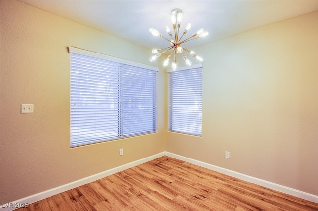 unfurnished room with a chandelier and light hardwood / wood-style floors