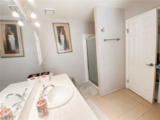 bathroom featuring a shower with door, tile patterned flooring, and sink