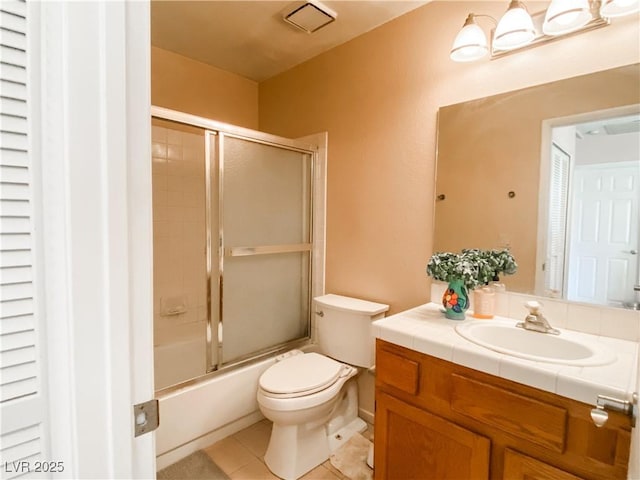 full bathroom featuring vanity, tile patterned flooring, bath / shower combo with glass door, and toilet