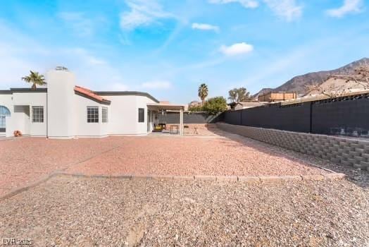 back of house with a mountain view and a patio area