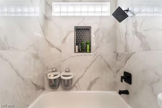 bathroom featuring tiled shower / bath and a healthy amount of sunlight