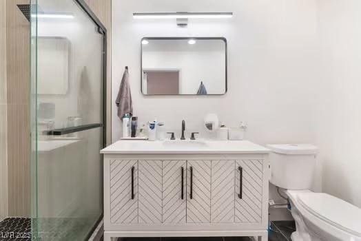 bathroom featuring vanity, an enclosed shower, and toilet