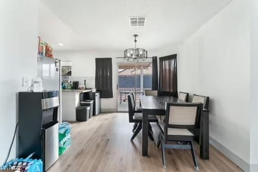 dining room featuring a notable chandelier and light hardwood / wood-style flooring