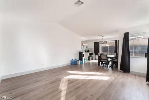 living room with an inviting chandelier and light wood-type flooring