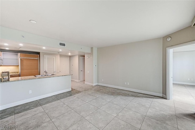 unfurnished living room featuring sink and light tile patterned floors