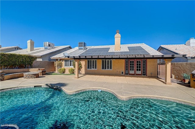 view of swimming pool with cooling unit, a fire pit, and a patio area