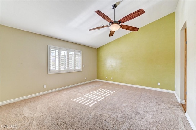 carpeted spare room featuring vaulted ceiling and ceiling fan