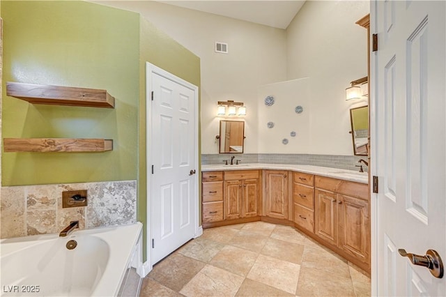 bathroom with tasteful backsplash, vanity, and a washtub