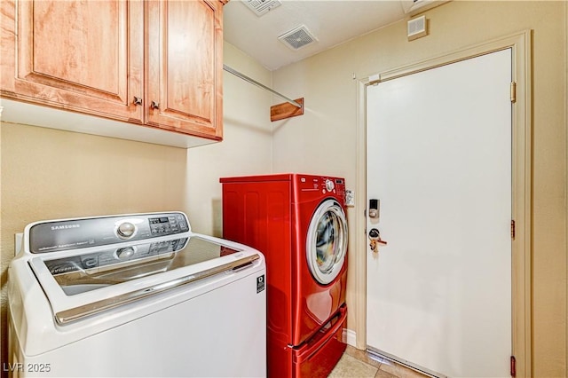 laundry room featuring washer and clothes dryer, cabinets, and light tile patterned flooring