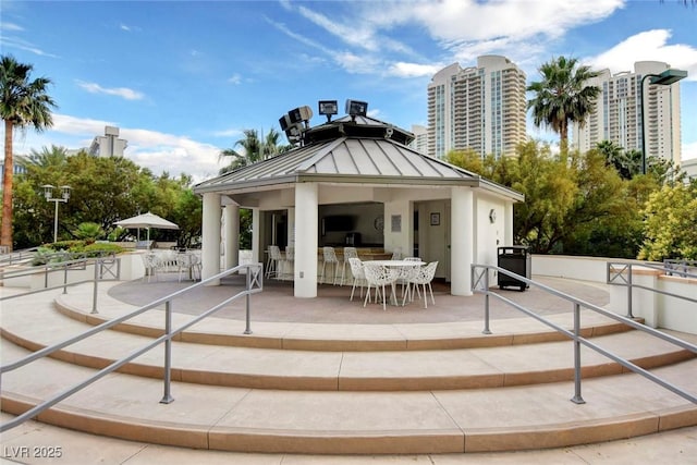 back of property featuring a gazebo and a bar