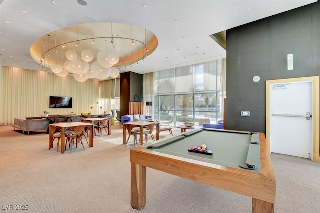 game room featuring light carpet, floor to ceiling windows, and a raised ceiling