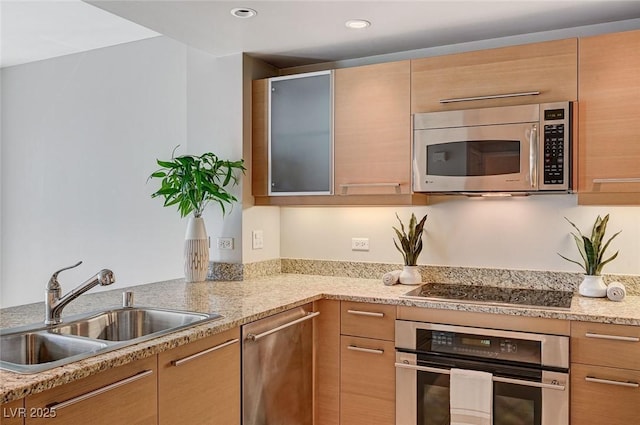 kitchen featuring light stone counters, appliances with stainless steel finishes, sink, and light brown cabinets