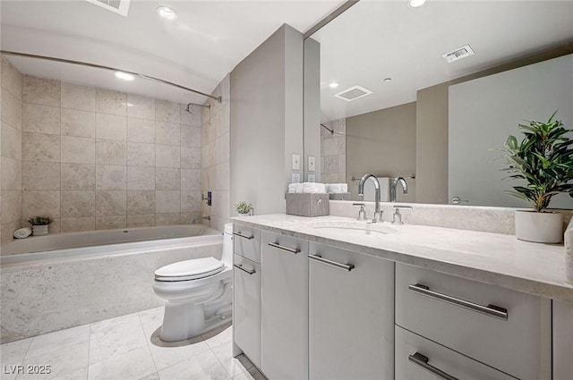 full bathroom with vanity, tiled shower / bath combo, and toilet