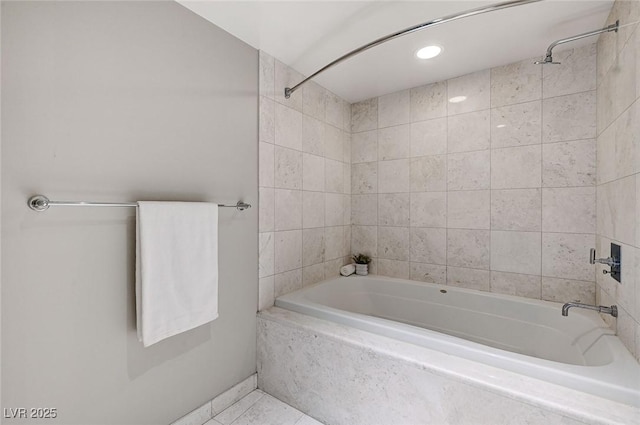 bathroom featuring tile patterned flooring and tiled shower / bath