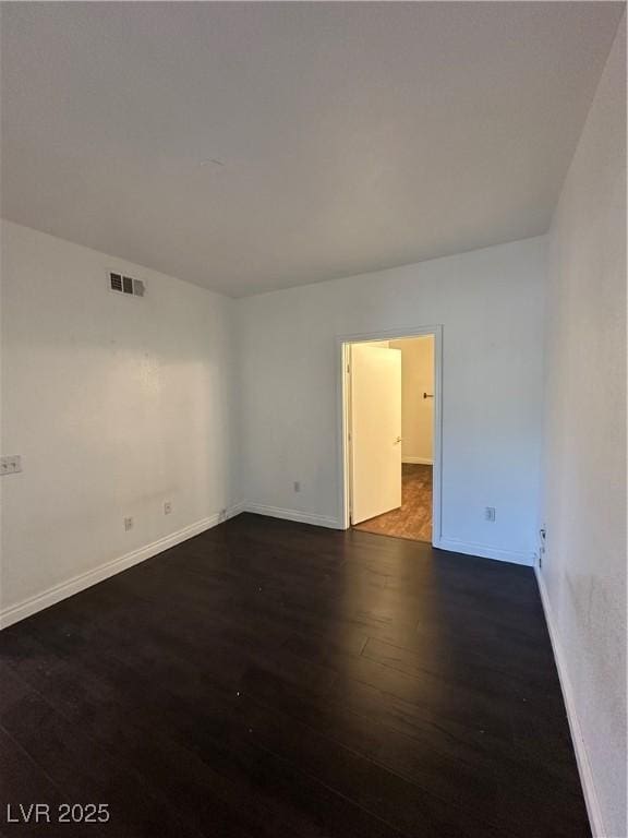 spare room with dark hardwood / wood-style flooring