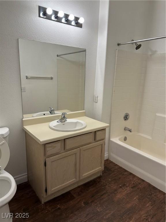 full bathroom featuring wood-type flooring, bathtub / shower combination, vanity, and toilet