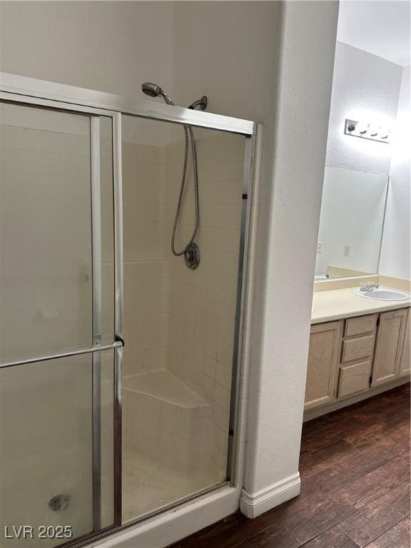 bathroom featuring vanity, an enclosed shower, and hardwood / wood-style flooring