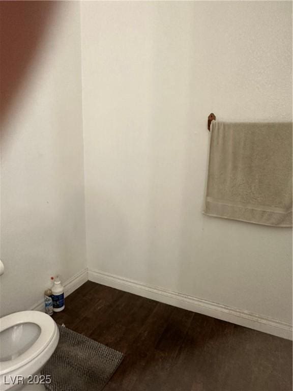 bathroom with toilet and hardwood / wood-style floors