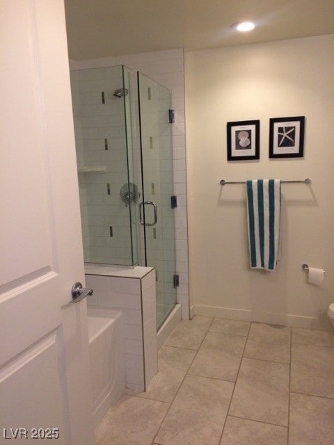 bathroom featuring tile patterned flooring, a shower with door, and toilet