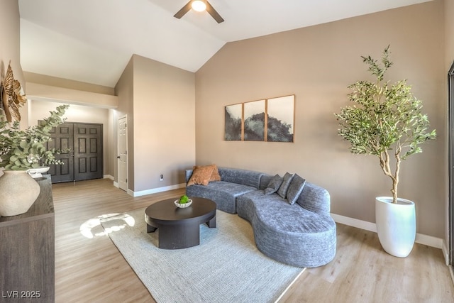 living room featuring vaulted ceiling, ceiling fan, and light wood-type flooring